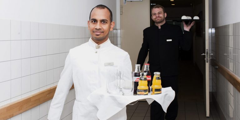 Ein Kellner rägt ein Tablett