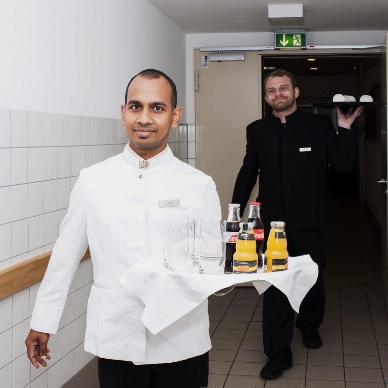 Ein Kellner rägt ein Tablett