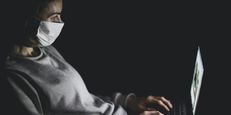 Geflüchtete mit Maske und Laptop