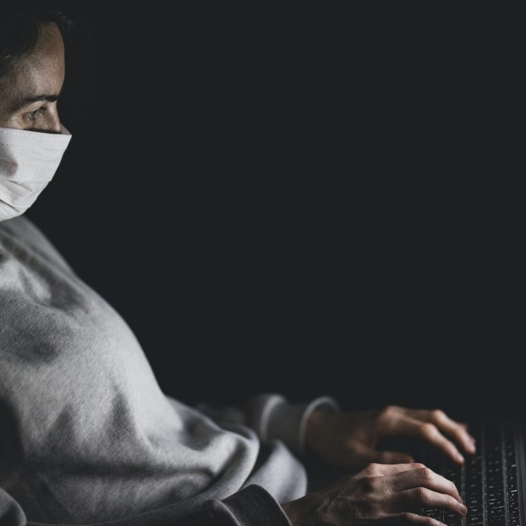 Geflüchtete mit Maske und Laptop