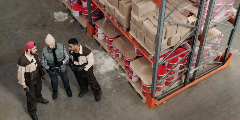 Drei Lagerarbeiter in einer Halle