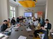 Teilnehmende des Programms SHK Kompass sitzen gemeinsam bei einem Treffen des Programms an einem Tisch.