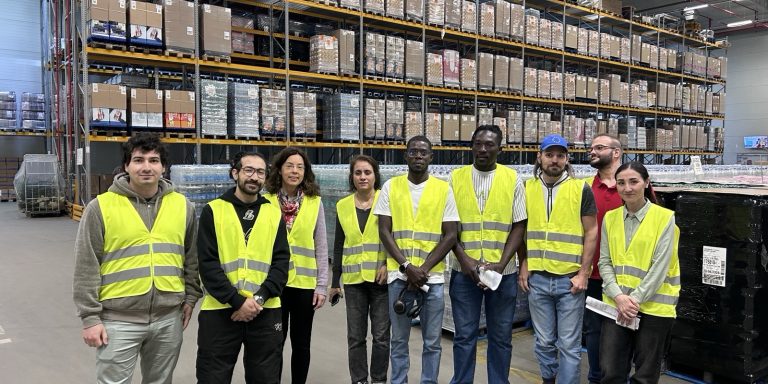 Teilnehmende und Mitarbeitende von ARRIVO BERLIN Dienstleistung bei der Lagerbesichtigung bei REWE Berlin Logistik