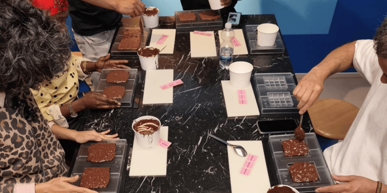 Teilnehmende von ARRIVO BERLIN Hospitality bei der Herstellung eigener Schokoladenkreationen im RITTER SPORT Workshop