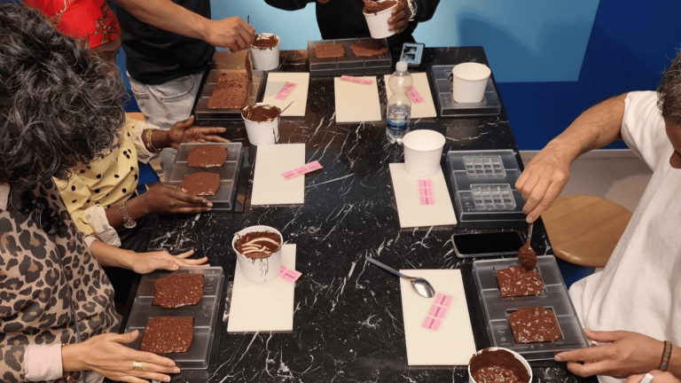 Teilnehmende von ARRIVO BERLIN Hospitality bei der Herstellung eigener Schokoladenkreationen im RITTER SPORT Workshop
